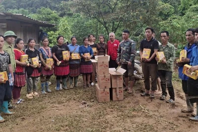 Đại diện Hội Chữ thập đỏ tỉnh Điện Biên trao hàng cứu trợ cho người dân. 