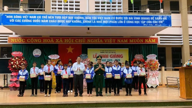 Đại diện xã Ia O và Ban Chỉ huy Bộ đội Biên phòng tỉnh trao quà cho các em học sinh tại lễ khai giảng.
