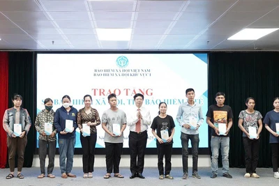 Trao tặng sổ bảo hiểm xã hội, thẻ bảo hiểm y tế cho người dân có hoàn cảnh khó khăn ở Hà Nội, tháng 7/2025. (Ảnh VSS)