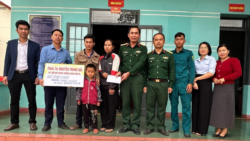 Thiếu tá Quân nhân chuyên nghiệp Nguyễn Trung Hải (thứ 5 từ phải sang), nhân viên Quân lực, Ban Chỉ huy Quân sự xã Ia Rvê cùng lãnh đạo xã Ea Kiết trao tiền các nhà hảo tâm hỗ trợ cháu Dương Quốc Khánh.