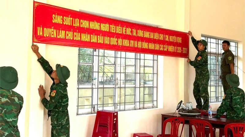 Cán bộ, chiến sĩ Đồn Biên phòng Xuân Hòa treo băng rôn tuyên truyền, hoàn thiện công tác trang trí tại khu vực bỏ phiếu trên địa bàn xã Xuân Cảnh.