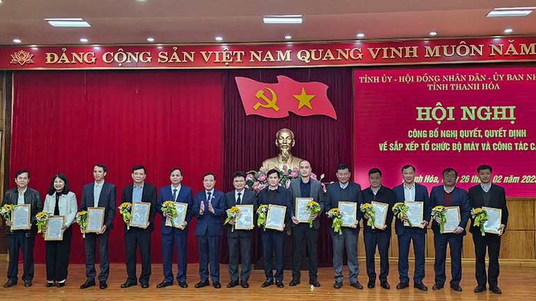 Phó Bí thư Thường trực Tỉnh ủy, Chủ tịch Hội đồng nhân dân tỉnh Thanh Hóa trao quyết định, tặng hoa cho các cán bộ được điều động, bổ nhiệm.