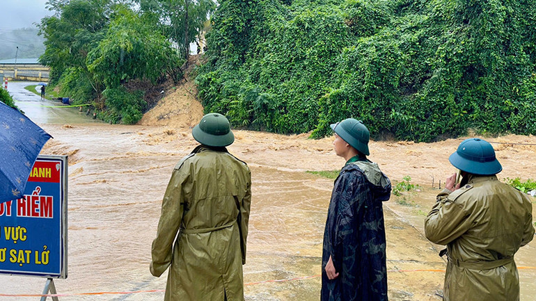 Lực lượng chức năng chặn, gác tại điểm đường giao thông ngập nước.