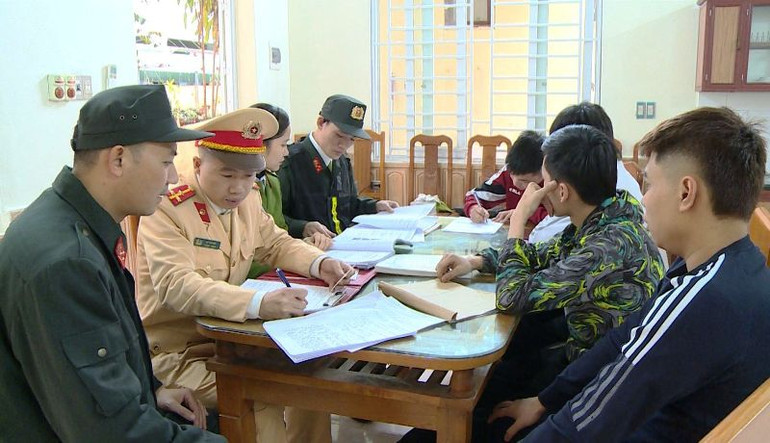 Công an làm việc với các thanh niên có hành vi vi phạm khi tham gia giao thông đường bộ.