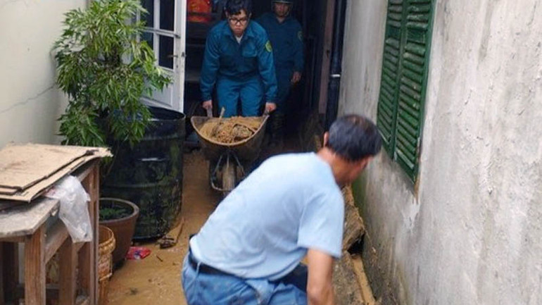 Lực lượng chức năng hỗ trợ người dân khắc phục hậu quả do mưa lớn.