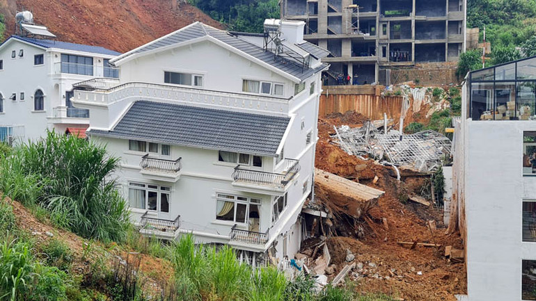 Ngôi nhà bị xô lệch, nghiêng bên sườn đồi sau vụ sạt lở.