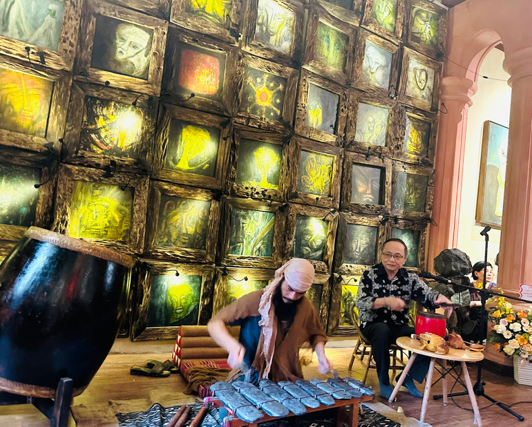 Tiến sĩ Trịnh Thắng biểu diễn đàn đá tại buổi khai mạc triển lãm “Rung động từ hư vô”.