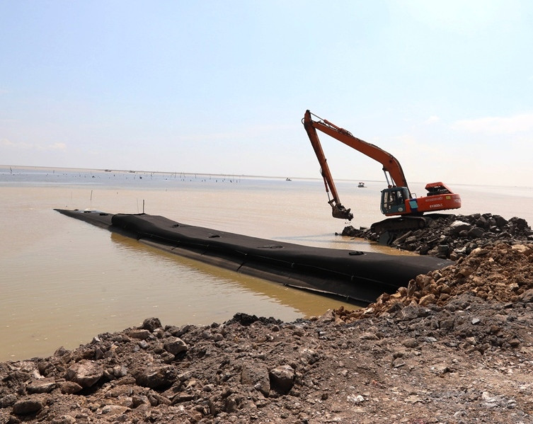 Phương tiện cơ giới thi công chống sạt lở, nước mặn xâm thực bờ biển ở xã Hoằng Phụ.