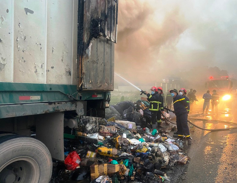 Lực lượng chức năng phun nước dập lửa cháy trong container chở hàng hóa.