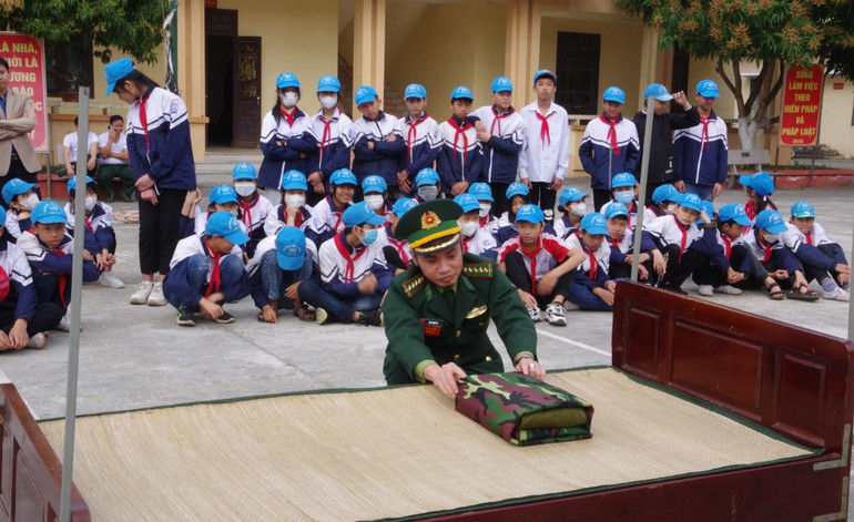 Các em học sinh phổ thông trên địa bàn xã Thái Đô xem cách thức gấp tư trang của cán bộ, chiến sĩ Bộ đội Biên phòng.