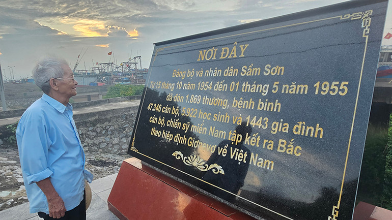 Ông Trần Chí Trác đọc các thông tin tại nơi từng đón đồng bào, cán bộ, chiến sĩ, học sinh miền nam tập kết tại bến Hới.