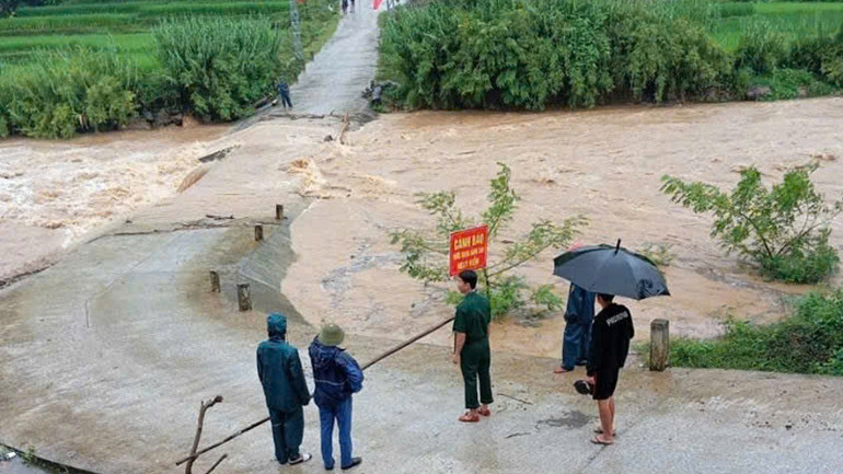 Lực lượng chức năng gác chặn điểm đường tràn giao thông bị ngập nước.