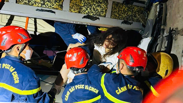 Người mắc kẹt trong xe ô-tô khách được cứu hộ, đưa ra ngoài.
