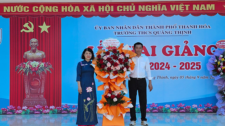 Đại diện hội phụ huynh tặng hoa chúc mừng cơ sở giáo dục.