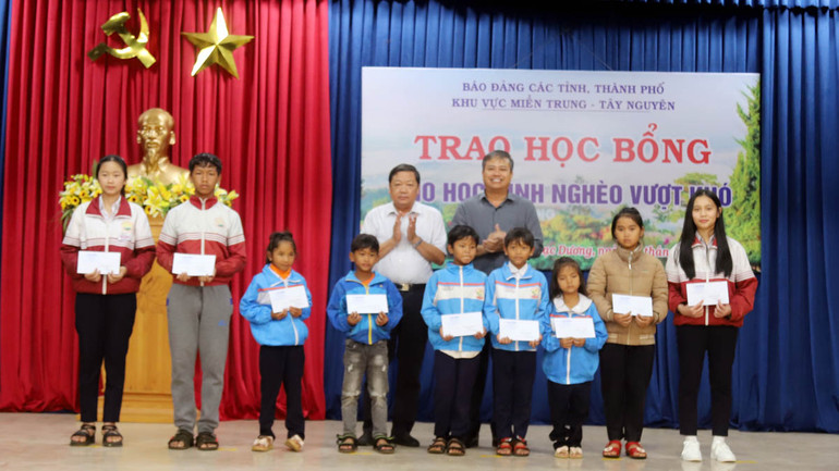 Đại diện Ban tổ chức Hội thảo báo Đảng các tỉnh, thành phố khu vực miền trung-Tây Nguyên trao học bổng tặng học sinh nghèo học giỏi.