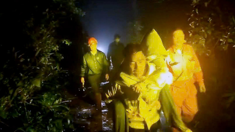 Lực lượng cứu hộ cõng sinh viên xuống núi.