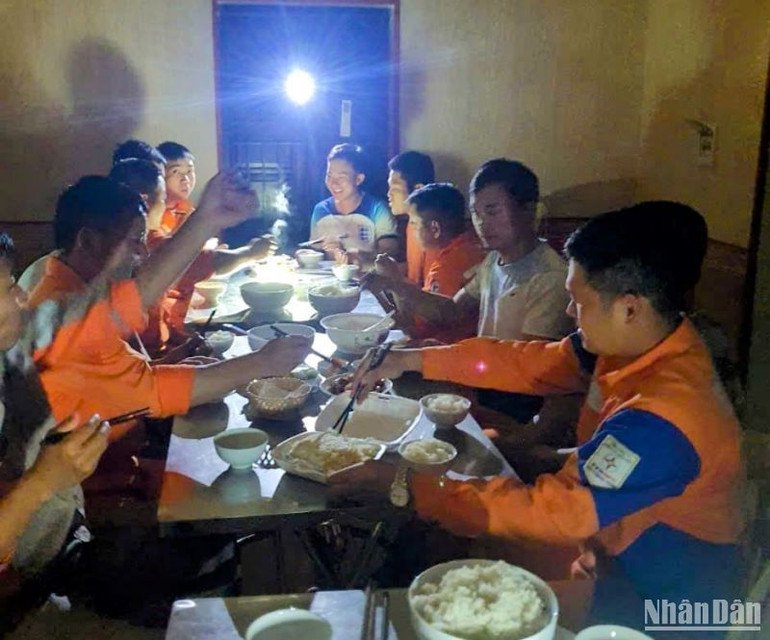 Công nhân Điện lực Thái Thụy tranh thủ ăn cơm tối để tiếp tục làm việc xuyên đêm.