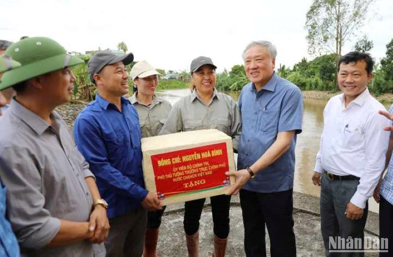 Đồng chí Nguyễn Hòa Bình tặng quà người lao động đang ứng trực khắc phục hậu quả bão số 3 tại tỉnh Thái Bình.
