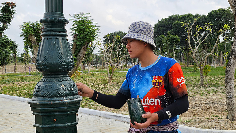 Người lao động sơn bảo vệ các cột điện ở Công viên Hội An, thành phố Thanh Hóa.