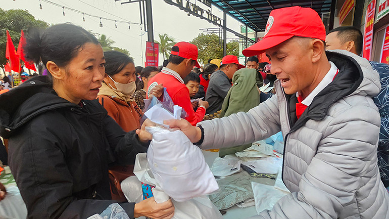 Tình nguyện viên Chữ thập đỏ trao tặng lương thực, đồ dùng thiết yếu cho người nghèo.