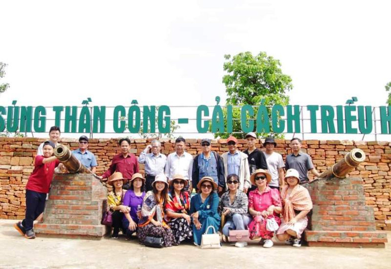 Du khách chụp ảnh lưu niệm bên điểm trưng bày súng thần công triều Hồ.