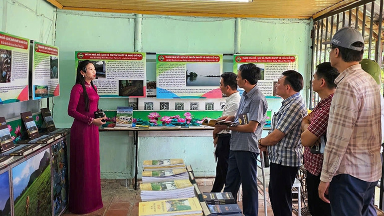 Những người làm báo nghe thuyết minh viên giới thiệu về kết quả khai quật khảo cổ học và không gian văn hóa Tây Đô.