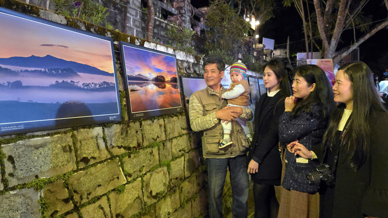 Người dân Đà Lạt cùng tác giả Võ Đình Trang bên những tác phẩm của anh.