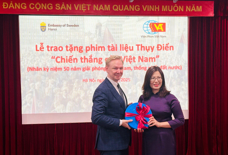 Ông Oscar Staffas Edström, Trưởng Ban Thương mại và Xúc tiến, Đại sứ quán Thụy Điển, trao tặng bộ phim cho đại diện Viện phim Việt Nam. (Ảnh: Kim Lĩnh)