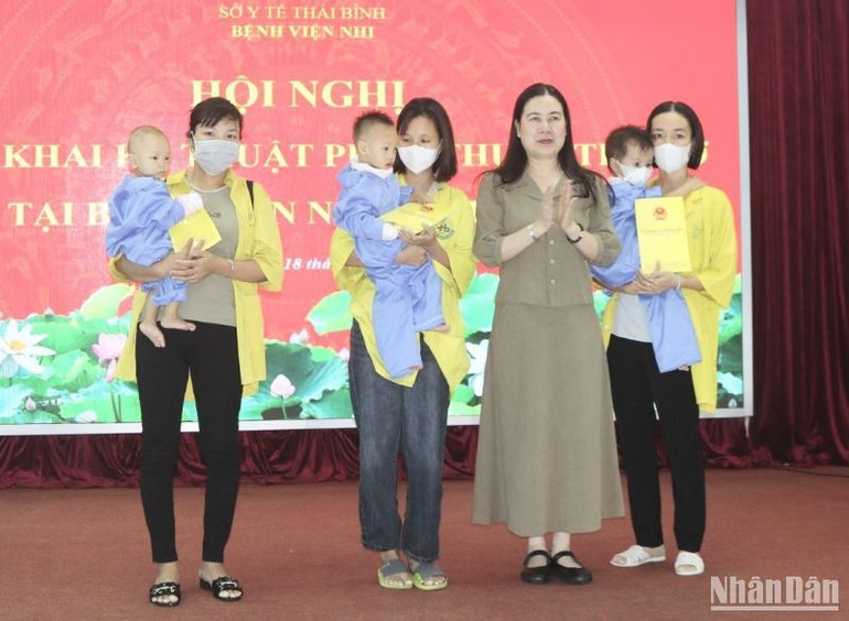 Phó Chủ tịch Ủy ban nhân dân tỉnh Thái Bình Trần Thị Bích Hằng trao hỗ trợ kinh phí cho 3 trẻ em được phẫu thuật tim hở dịp này.