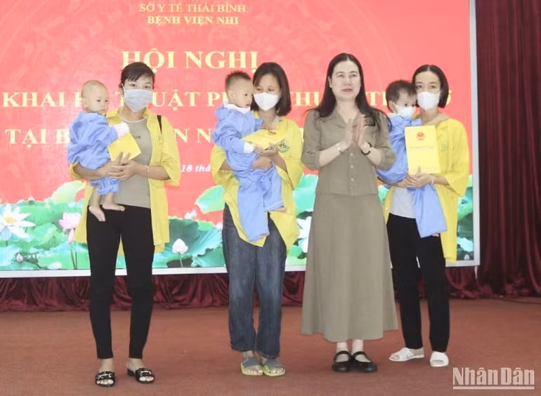 Phó Chủ tịch Ủy ban nhân dân tỉnh Thái Bình Trần Thị Bích Hằng trao hỗ trợ kinh phí cho 3 trẻ em được phẫu thuật tim hở dịp này.