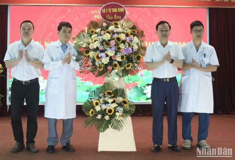 Tiến sĩ Phạm Quang Hòa, Giám đốc Sở Y tế tỉnh Thái Bình tặng hoa chúc mừng kíp phẫu thuật tim hở Bệnh viện Nhi Thái Bình.
