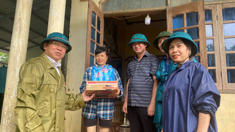 Cán bộ ở huyện Thạch Thành cấp phát nước đồ ăn, nước uống cho hộ dân bị ngập nước.