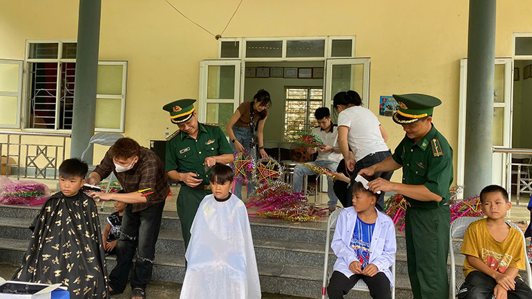 Bộ đội Biên phòng cắt tóc cho trẻ em.