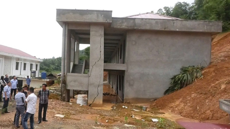 Đoàn công tác liên ngành kiểm tra công trình đang thi công bị hư hỏng do sạt, lở đất đồi từ phía sau.