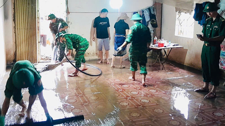 Bộ đội Biên phòng trợ giúp hộ dân dọn bùn đất tràn vào nhà.