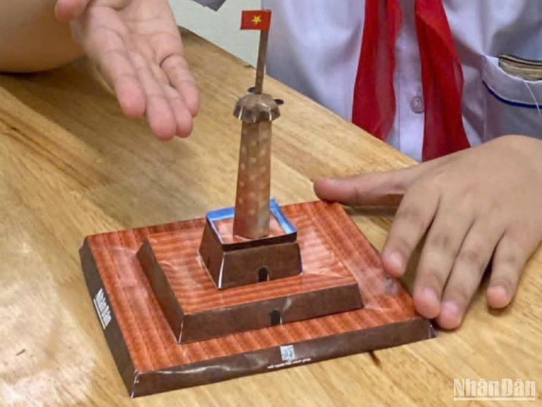 Cột cờ Hà Nội hiện ra sinh động sau khi cắt ghép hoàn chỉnh theo hướng dẫn trên ấn phẩm đặc biệt do Báo Nhân Dân xây dựng.