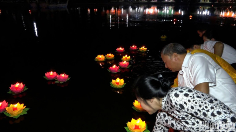 Đại diện lãnh đạo Huyện ủy, Ủy ban nhân dân huyện Vũ Thư thả những bông hoa đăng xuống hồ nước trong Khu di tích quốc gia đặc biệt chùa Keo.