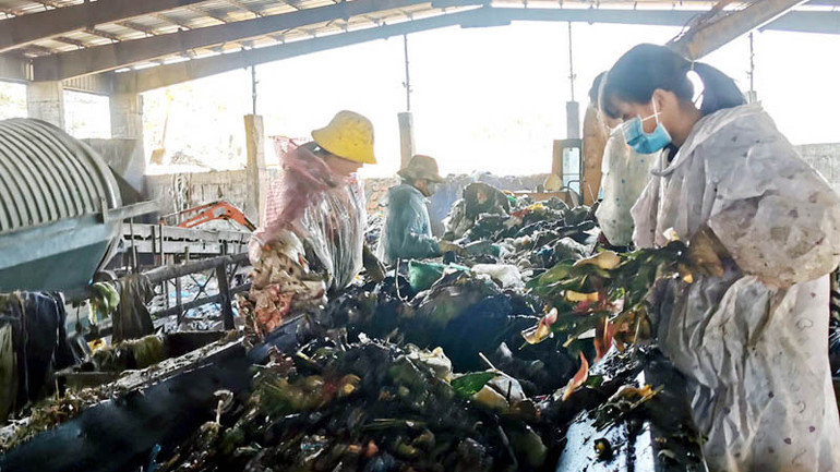 Công nhân phân loại rác trên dây chuyền xử lý rác thải.