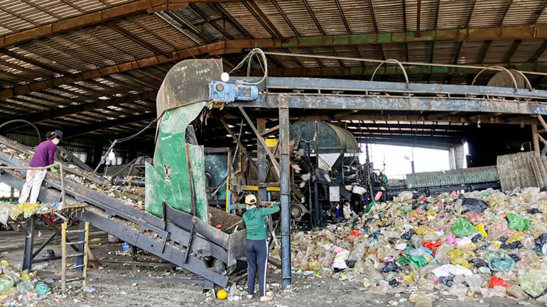 Công nhân xử lý rác tại nhà máy.