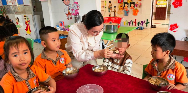 Cô giáo chăm sóc trẻ thấp, còi.