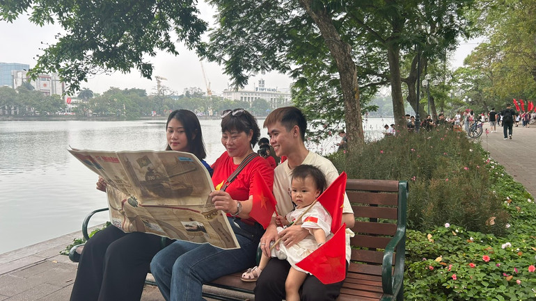 Gia đình bà Hoa gồm 3 thế hệ trải nghiệm đọc tờ phụ san đặc biệt của Báo Nhân Dân Gia đình bà Hoa gồm 3 thế hệ trải nghiệm đọc tờ phụ san đặc biệt của Báo Nhân Dân