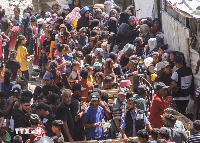 Người dân chen chúc nhận thức ăn cứu trợ tại trại tị nạn Jabalia ở Dải Gaza. (Ảnh:THX/TTXVN)