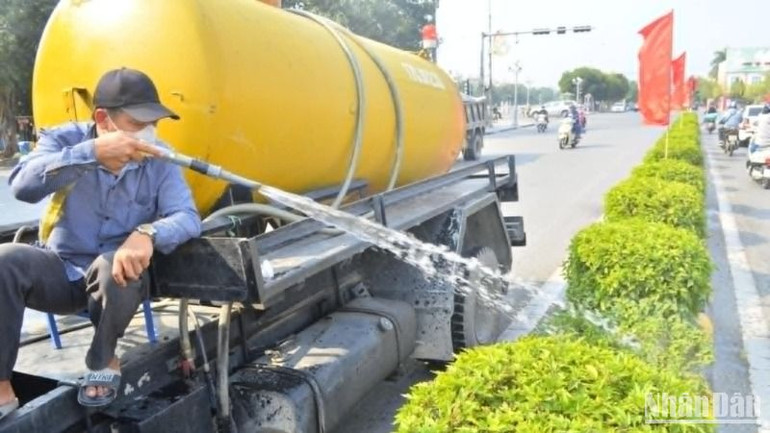 Công nhân Công ty Môi trường và Công trình đô thị chăm sóc, tưới nước cho các bồn cây trong thành phố Thái Bình.