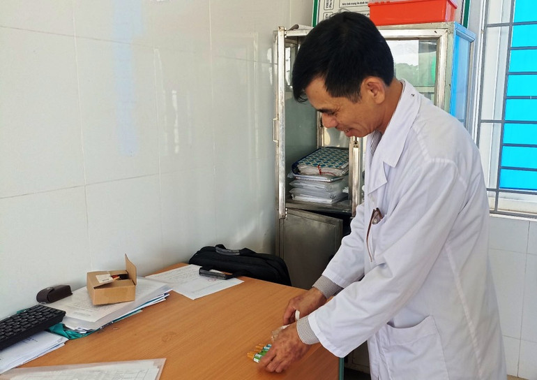 Cán bộ Trạm y tế xã Thăng Bình kiểm tra lại vỏ vaccine đã tiêm cho trẻ em.