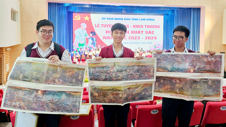 Các học sinh xuất sắc tỉnh Lâm Đồng thích thú khi được tặng ấn bản tranh panorama "Chiến dịch Điện Biên Phủ" tại lễ tuyên dương.