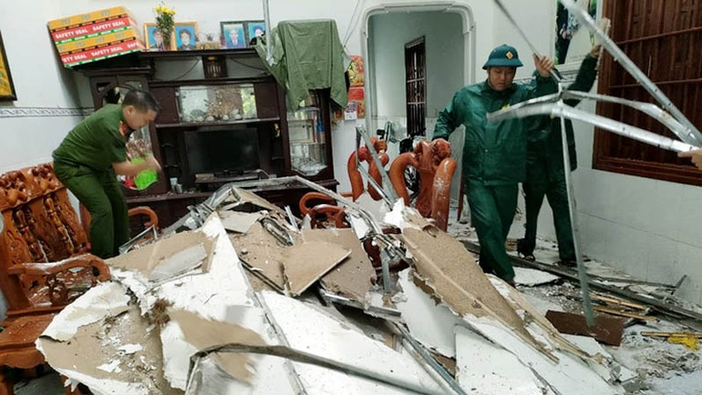 Lực lượng chức năng hỗ trợ người dân dọn dẹp nhà cửa sau khi bị tốc mái.