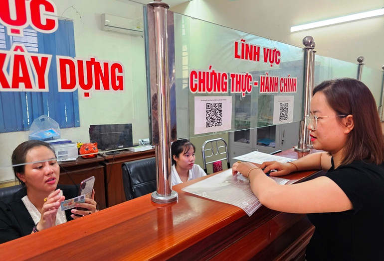 Cán bộ hướng dẫn công dân ứng dụng công nghệ giải quyết thủ tục hành chính.