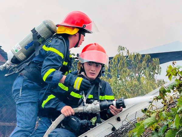 Lực lượng chuyên nghiệp sử dụng vòi rồng dập lửa.