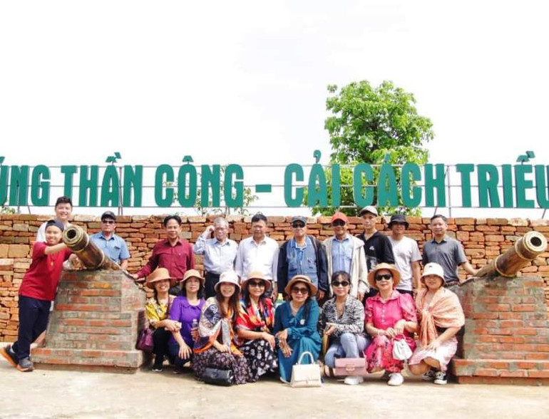 Du khách chụp ảnh với sản phẩm phục chế súng thần công triều Hồ.