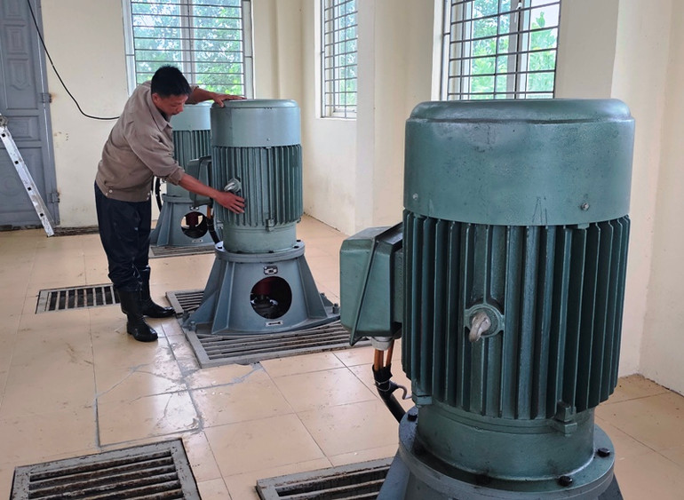 Công nhân doanh nghiệp thủy nông kiểm tra thiết bị, vận hành bơm tiêu thoát nước.